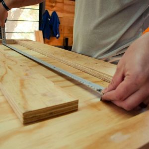 person in white shirt holding brown wooden table